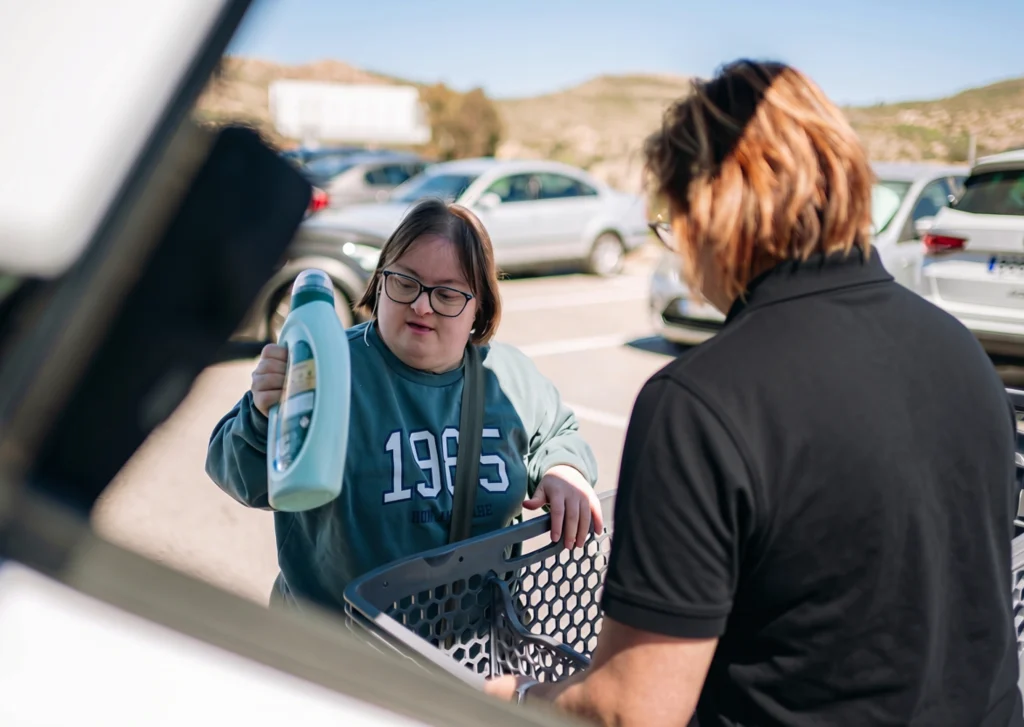 Velocity support worker helping a client load groceries into a car